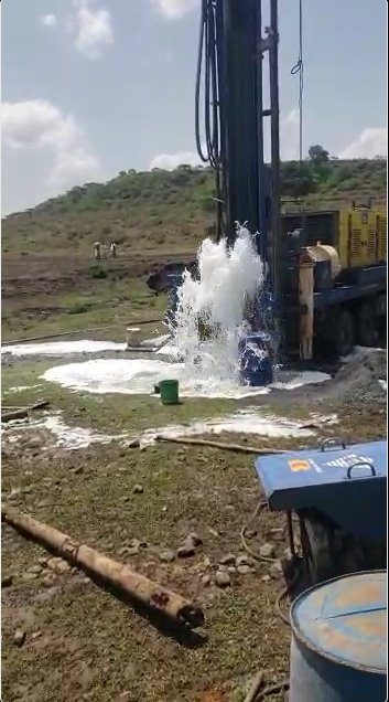 Water gushing from the newly drilled well at thirty liters per second